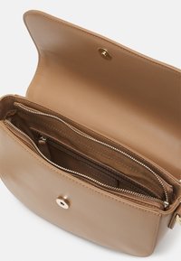 Brun lädercrossbody-väska med en slät yta, magnetisk knäppning och inre dragkedjefack. Har en ren, minimalistisk design.