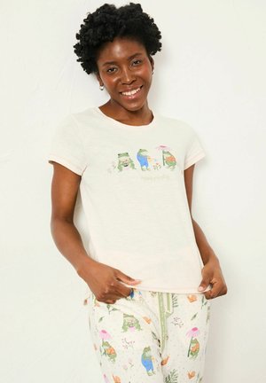 Light pastel t-shirt with frog graphics, short sleeves, and a crew neck. Paired with patterned pajama pants featuring floral and frog motifs.