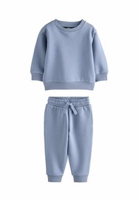 Lyseblå sweatshirt og joggingbukser i blødt materiale. Sweatshirten har en rund halsudskæring og ribbede manchetter; joggingbukserne har en elastisk talje.