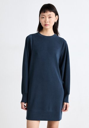 Mørkeblå sweatshirtkjole laget av mykt stoff, med lange ermer, rund halsringning og en avslappet passform med en nederste kant over kneet.