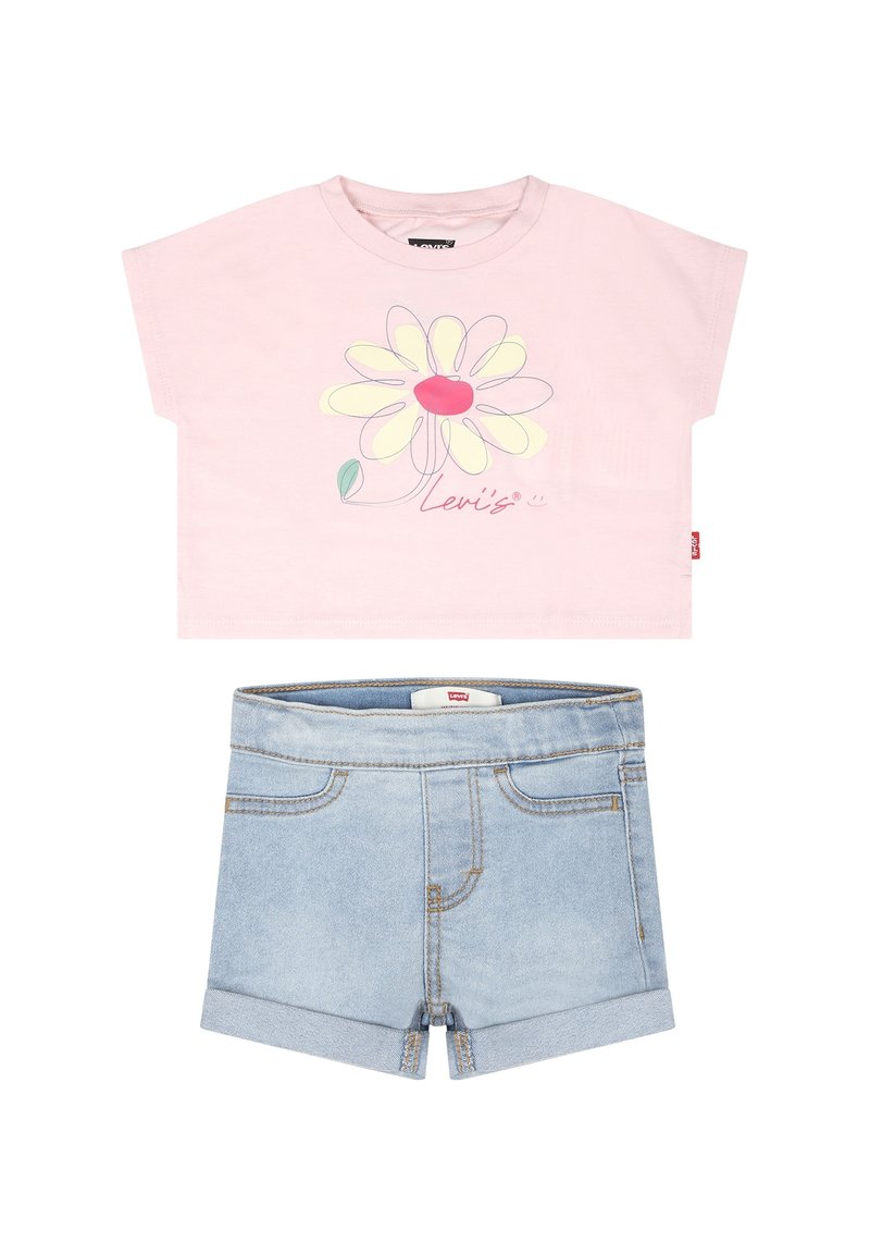 Camiseta de algodón rosa de manga corta con un diseño floral y el texto "Levi's", combinada con pantalones cortos de mezclilla azul claro con los dobladillos enrollados.