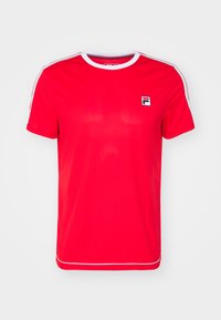 Camiseta deportiva roja hecha de tela suave, con cuello redondo acanalado, acentos blancos en las mangas y un pequeño logo en el lado izquierdo del pecho.