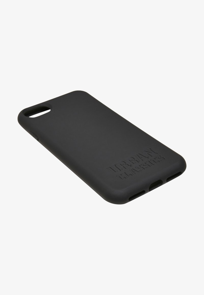 Melnas silikona telefona apvalks ar matētu virsmu, kuram ir iegravēts "URBAN CLASSICS" logo un izgriezumi portiem un kamerai.