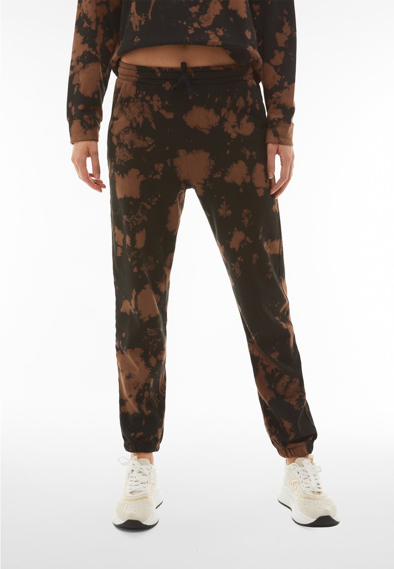 Black and brown tie-dye joggers made of soft fabric, featuring an elastic waistband, cuffed ankles, and a relaxed fit design.