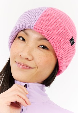 Gebreide beanie met afwisselende secties van roze en lavendel, met een ribbelstructuur en een klein zwart label aan de zijkant.