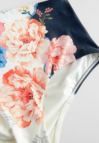 Gėlėtas bikini apatinis trikotažas su dideliais rožiniais ir oranžiniais pionų raštais ant kremavimo fono, su tamsiai mėlynomis detalėmis ir glotnia tekstilės apdaila.