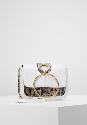 Witte crossbodytas met slangenhuidpatroon, gouden ringdetail en kettingriem, geplaatst op een wit oppervlak tegen een grijze achtergrond.