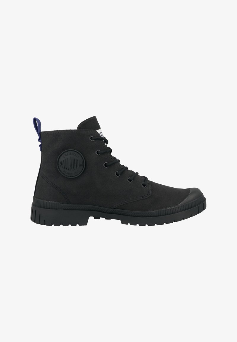 Botas de tobillo negras de ante, con suela de goma, puntera redonda, diseño de cordones y un parche de logo circular en el lado exterior.