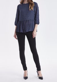 Námořnická blůza s texturou, tříčtvrtečními rukávy a řaseným peplum zakončením, zkombinovaná s černými upnutými kalhotami a černými lodičkami s špičatou špičkou.