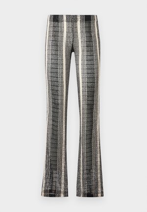 Sort-hvide, vertikalt striped strikkede bukser med let udvidede ben og tekstureret mønster mod en ensfarvet baggrund.