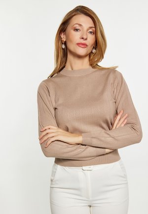 Hellbraunes, geripptes Sweatshirt mit Rundhalsausschnitt, langen Ärmeln und schmalem Saum, kombiniert mit weißen, maßgeschneiderten Hosen. Glatte Textur.