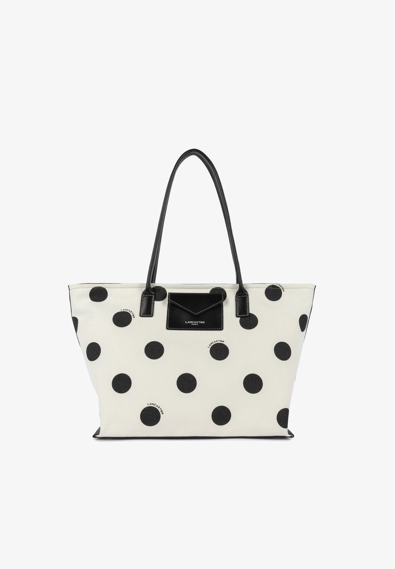 Sac fourre-tout blanc à pois noirs, avec des anses noires et une petite poche avant portant l'étiquette "Lancaster Paris".