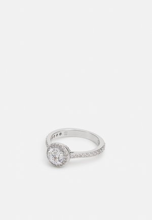 Runder silberner Ring mit einem zentralen ovalen Diamanten, der von kleineren Steinen umgeben ist, auf einem glatten Band. Er zeichnet sich durch ein poliertes Finish und filigrane Details aus.