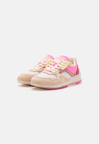 Beige und rosa Sneaker aus strukturierten Materialien, mit Netzpaneelen und kontrastierenden Schnürsenkeln. Sie verfügen über eine klobige Sohle mit rosa Akzenten.
