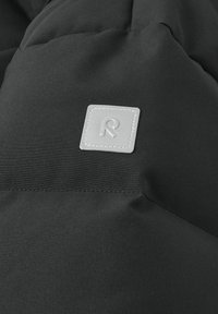Czarna, pikowana tkanina o gładkiej teksturze; z szarym, kwadratowym wykończeniem z wytłoczonym logo; proste przeszycia wzdłuż szwów.