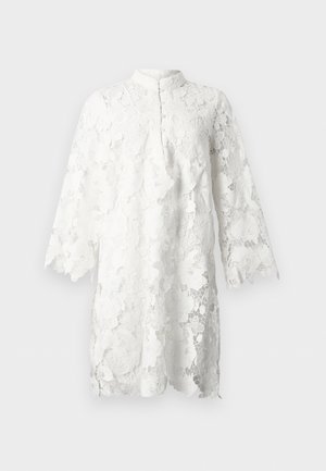 Λευκό δαντελένιο φόρεμα με λουλουδάτα μοτίβα, μακριά μανίκια, ψηλό γιακά και κυματιστές άκρες στα μανίκια και στο τελείωμα.