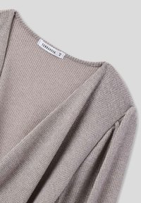 Maglione grigio chiaro con trama, scollo a V, maniche arricciate e motivo intrecciato. Presenta un'etichetta del marchio visibile: Terranova, taglia S.