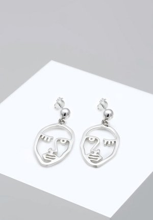 Silver earrings featuring a minimalist face design with cut-out details, a round bead accent at the top, and a polished finish.