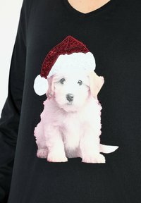 Schwarzes Langarmshirt mit einem bedruckten weißen Welpen, der einen glitzernden roten und weißen Weihnachtsmann-Hut auf der Vorderseite trägt.