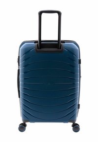 Maleta rígida de color azul oscuro con un diseño estriado. Cuenta con un mango negro retráctil y cuatro ruedas para mayor movilidad.