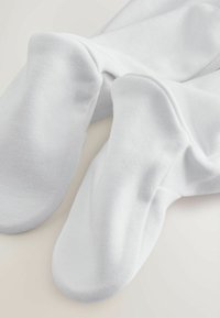 Witte katoenen sokken met een gladde textuur en een naadloos teenontwerp, met een aansluitende pasvorm en zachte, rekbare stof.