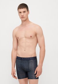 Σκούρες μπλε μποξεράκια με υφασμάτινο σχέδιο, ελαστική μέση που διαθέτει το λογότυπο "BJÖRN BORG", στενή εφαρμογή και μήκος μέχρι το μεσαίο μέρος των μηρών.