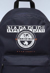 Mochila navy hecha de un tejido duradero, con un gran logotipo blanco, un gráfico de investigación de la Antártida y detalles en naranja en la parte frontal.