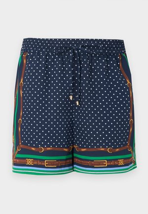 Pantaloncini blu navy con pois bianchi, vita elasticizzata, chiusura con coulisse e dettagli decorativi con cinturini marroni e rifiniture verde-blu.