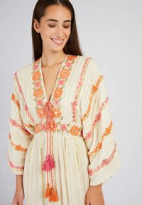 Helles Kaftan mit floralem Stickerei in Orange und Pink, verfügt über einen tiefen V-Ausschnitt, lange Ärmel und eine Quastenbindung mit lebhaften Akzenten.