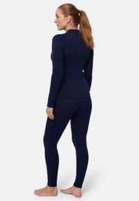 Navyblaue, enganliegende Thermo-Oberteil und Leggings aus weichem, dehnbarem Material. Mit langen Ärmeln und nahtlosem Design für zusätzlichen Komfort.