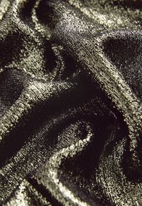 Zwarte en gouden textuurstof met een glanzende, metallic afwerking, met soepel vloeiende golven en intrikate patronen.