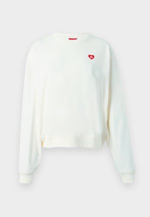 Svetlá krémová mikina s dlhými rukávmi, rebrovaným výstrihom a manžetami. Obsahuje malé červené srdiečkové logo na hrudi. Mäkko texturovaná tkanina.