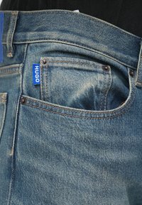 Φωτεινό γαλάζιο τζιν παντελόνι σε εφαρμοστή γραμμή, με ετικέτα «HUGO», ρεζεντέ ραφές και κλασικό σχέδιο με πέντε τσέπες.