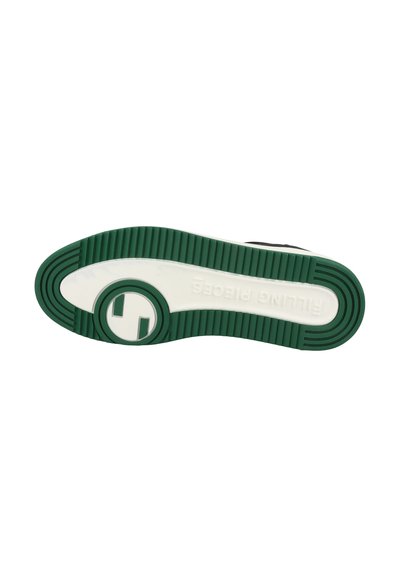 Svart textil sneakersula med vit mellansula och grön gummisula. Har en cirkulär logotyp och texturerat mönster för grepp.