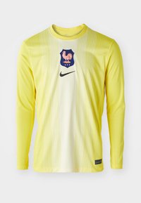 Dzeltena garās piedurknes džersija ar vertikālām svītrām. Vidū atrodas emblēma, un priekšpusē ir melns Nike logo. Teksturēta auduma.