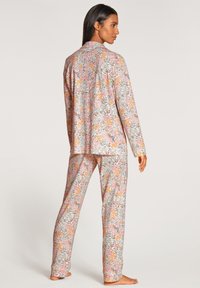 Floral Schlafanzug-Set aus leichtem, weichem Stoff in Pastellfarben mit einem lebhaften Blumenmuster und einer lockeren Passform.