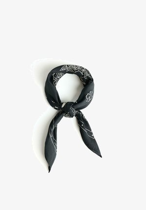 Czarna bandana z białymi wzorami kwiatowymi i geometrycznymi, złożona i związana luźnym węzłem na białym tle.
