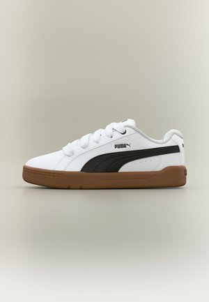 Fehér Puma sportcipő fekete oldalsávval és barna talppal, fehér fűzőkkel és Puma logóval az oldalon, semleges háttéren bemutatva.