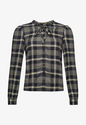 Blusa de manga larga con botones, con patrón de cuadros en negro y beige, cuello con volantes y lazo atado en el cuello.