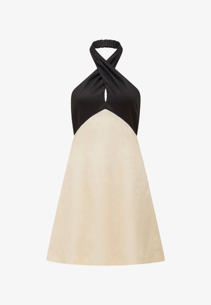 Halterneck kleita ar melnu augšdaļu un krēmkrāsas A līnijas svārkiem, kurai ir pagrieziena dizains ap kaklu un gluda tekstūra.