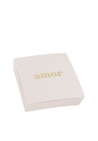 Scatola cosmetica quadrata di un delicato rosa con la scritta "amor" in oro embossato, caratterizzata da una finitura liscia e opaca e bordi arrotondati.