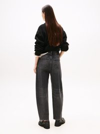 Suéter preto de malha com mangas bufantes, combinado com jeans de ganga escura de perna reta e cintura alta, apresentando bolsos traseiros e um desvanecimento subtil.