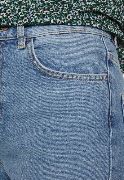 Ανοιχτού μπλε τζιν παντελόνι με ξεθωριασμένη υφή, που διαθέτει κλασική γραμμή, σχέδιο πέντε τσέπες και ενισχυμένα ρούχα κατά μήκος των ραφών.