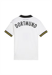 Balta polo marškinėliai su juodu apykakle ir geltonais akcentais. Ant nugaros išdidžiai užrašyta "DORTMUND" didelėmis juodomis raidėmis. Lygus paviršius.