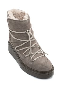 Botín de ante gris con un interior suave, punta redonda, suela gruesa y un notable detalle de cordones asegurados por un acento metálico.