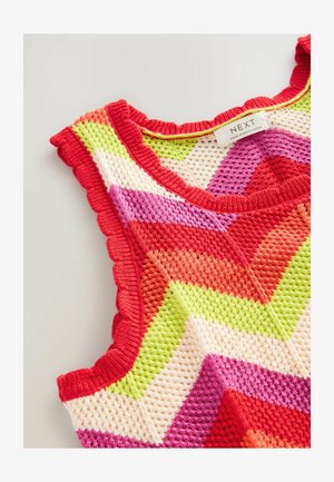 Dzianinowy top na ramiączkach z motywem w zygzak w kolorach czerwonym, różowym, zielonym, pomarańczowym i kremowym, z falbaniastymi krawędziami na kołnierzyku i otworach na rękawy.