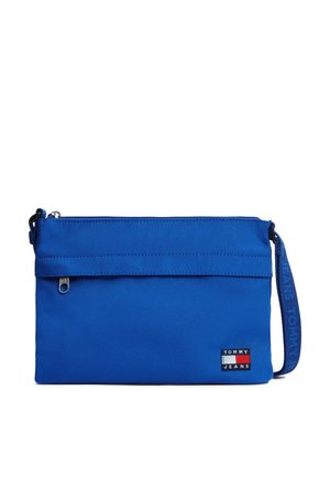 Sininen suorakaiteen muotoinen kangaspussi vetoketjulla, rannekahvalla, jossa lukee "Tommy Jeans", ja pienellä Tommy Jeans -logoplaasilla.