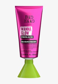 Bed Head Tigi Wanna Glow Hydrating Jelly Oil i en rosa tube med grønn kjegleformet base, 100 ml, med fet skrift og flerspråklige instruksjoner.