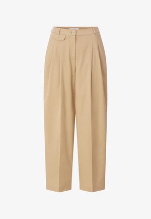 Bež hlače s visokim strukom, naborima, petljom za pojas s gumbom i suženim nogavicama, prikazane na bijeloj pozadini.