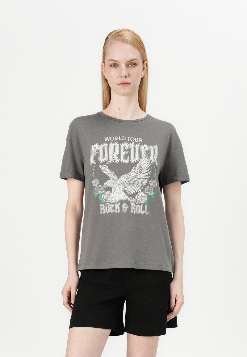 T-shirt grise à manches courtes avec un imprimé graphique représentant un oiseau, des roses et le texte "World Tour Forever Rock & Roll" en accents blancs et verts.